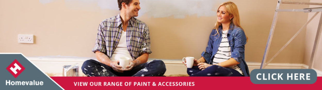 Two people sitting on a floor with paint cans, promoting Homevalue's range of paint and accessories.